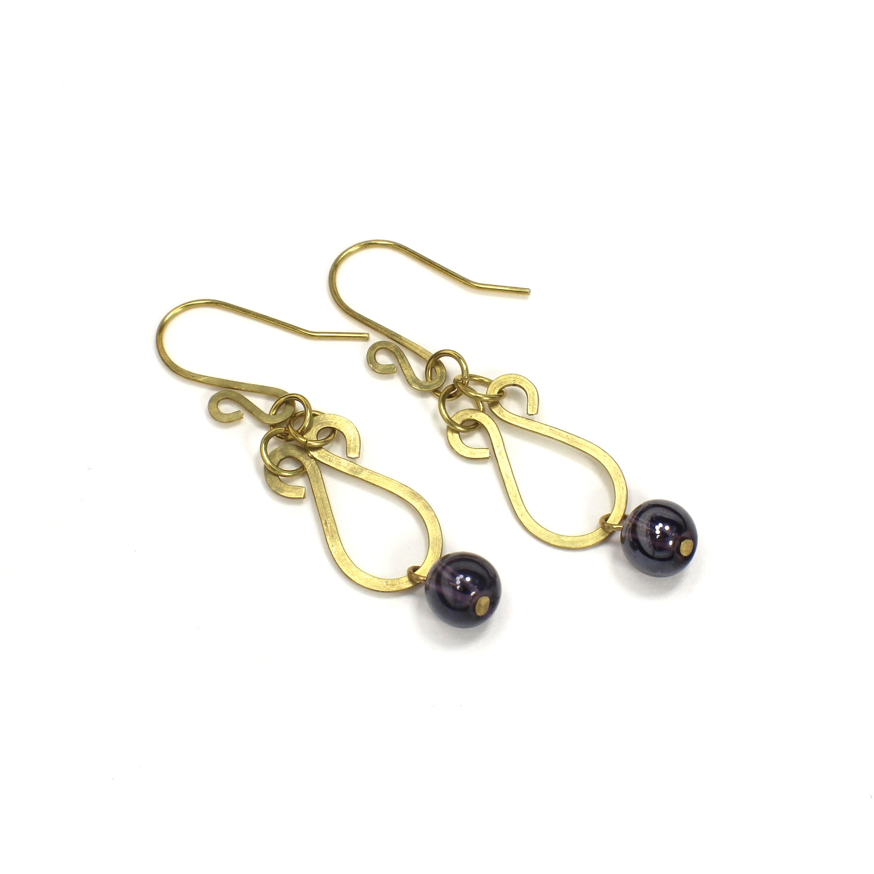 Hammered brass teardrop earrings with dark purple bead drops on a white background