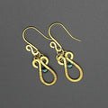 Hammered brass teardrop earrings wire-wrapped with metallic teal bead accents on a gray background.
