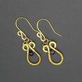 Brass hammered wire earrings with purple amethyst beads and wire wrapping on a gray background