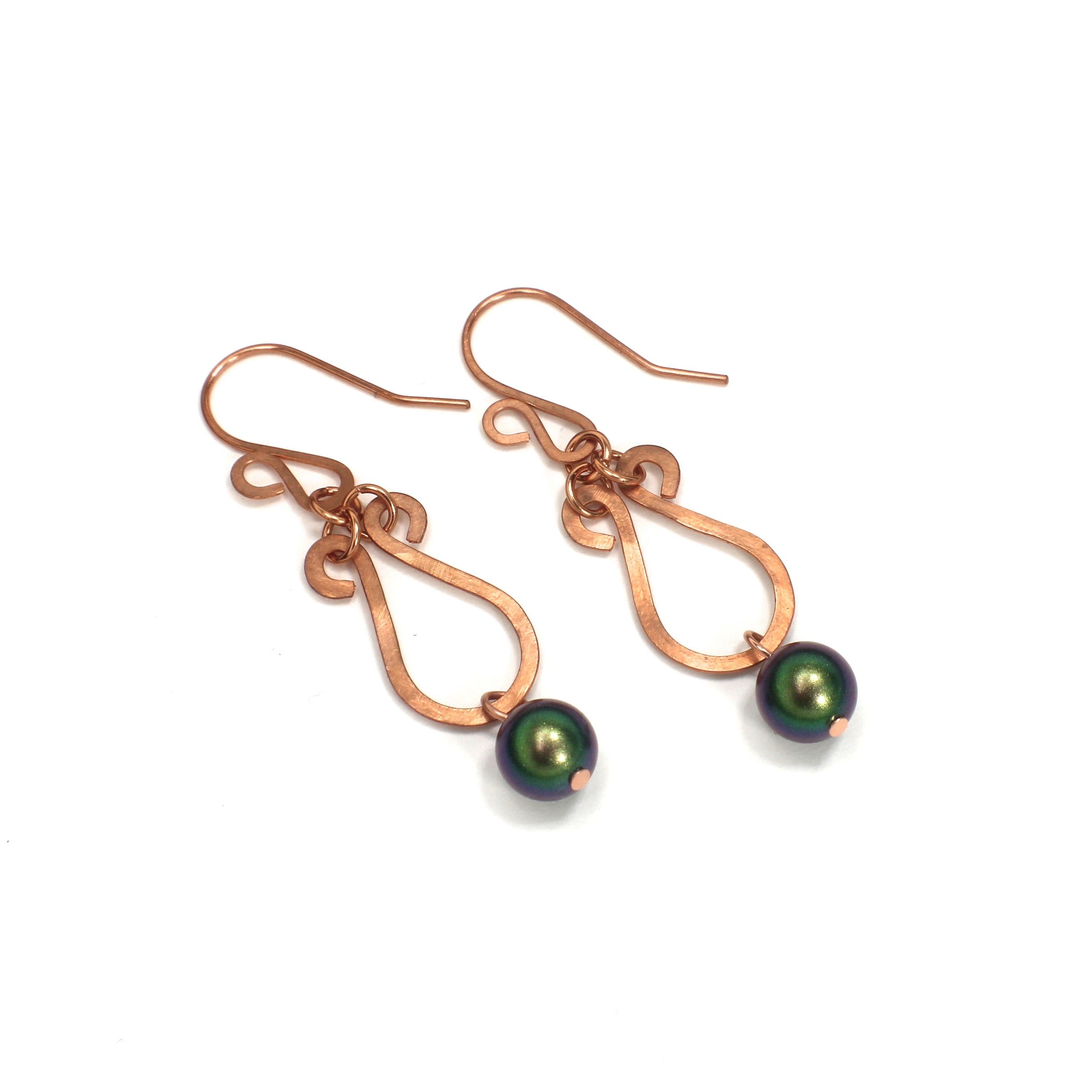 Pair of hammered copper teardrop earrings with green beads on a white background.