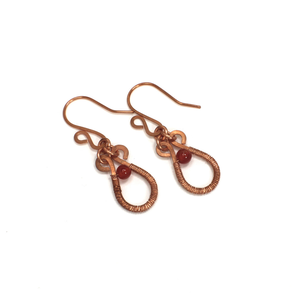 Flat copper teardrop earrings wire-wrapped with red carnelian bead accents  on a white background