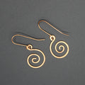 Copper spiral earrings on a gray background